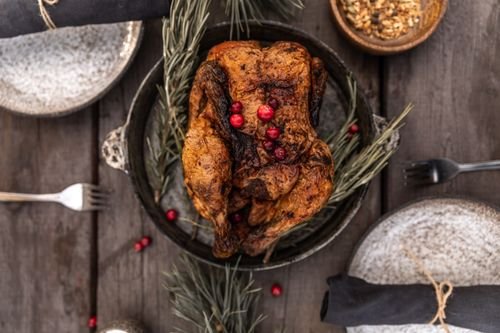 Roasted turkey garnished with cranberries on a festive holiday table