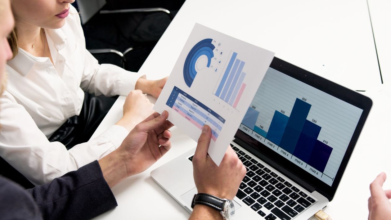Two people reviewing a printed financial report with charts during a credit assessment