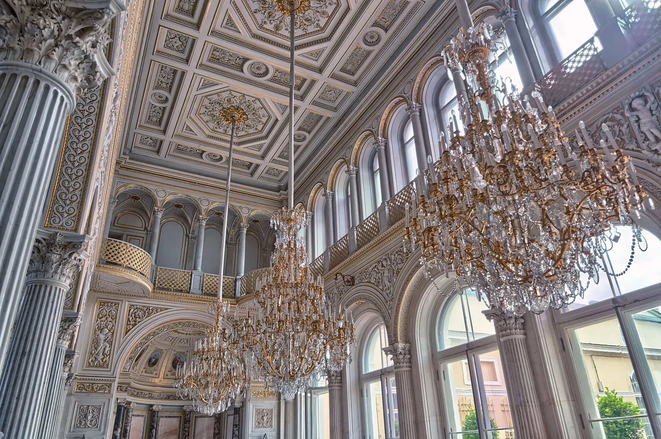 Crystal chandeliers and ornate plasterwork inside a grand historic hall
