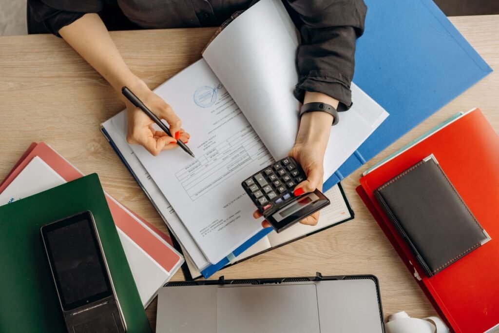 Business owner reviewing an invoice and documents with a calculator on a desk