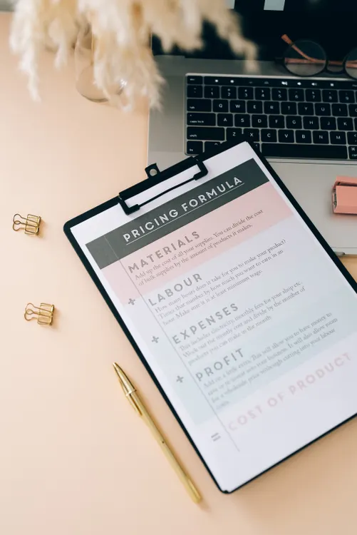 Pricing formula clipboard with materials labour expenses and profit notes