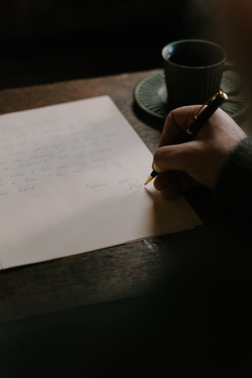Hand writing a professional letter with a fountain pen on paper