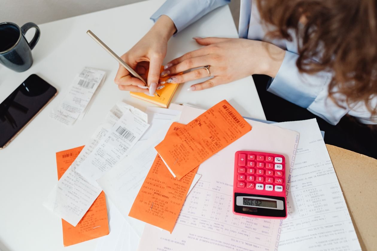 Receipts and a calculator on a desk showing freelance expense tracking