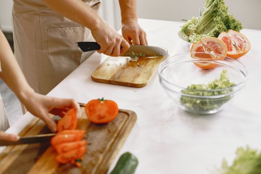 Two people chopping fresh vegetables together in a bright kitchen