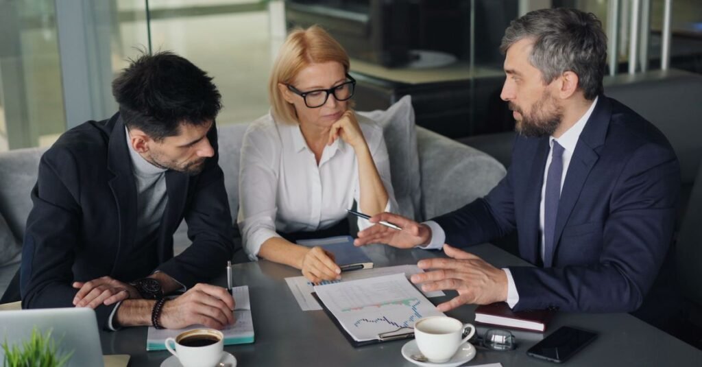Business owner discussing project documents with two clients